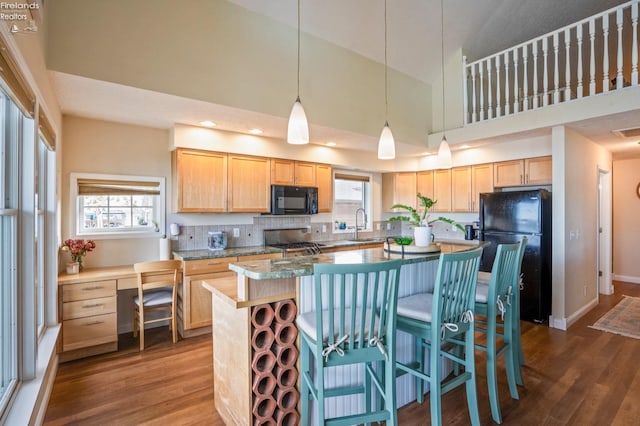 kitchen featuring black appliances, a kitchen island, dark hardwood / wood-style floors, and high vaulted ceiling