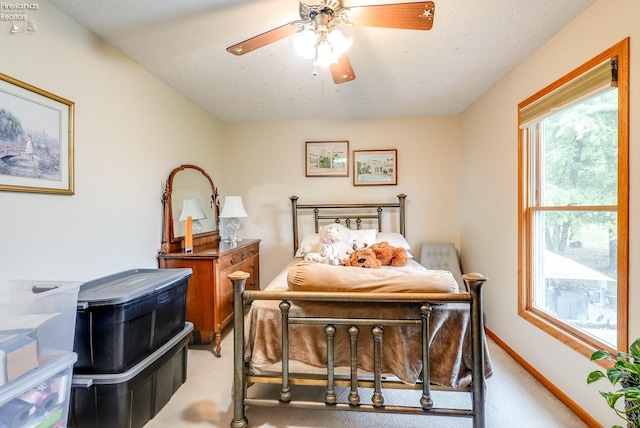 bedroom featuring carpet, ceiling fan, and a textured ceiling