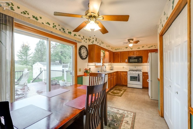 tiled dining space featuring ceiling fan and sink