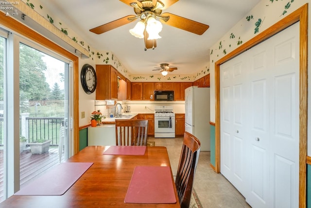 dining room featuring ceiling fan, light tile patterned floors, and sink