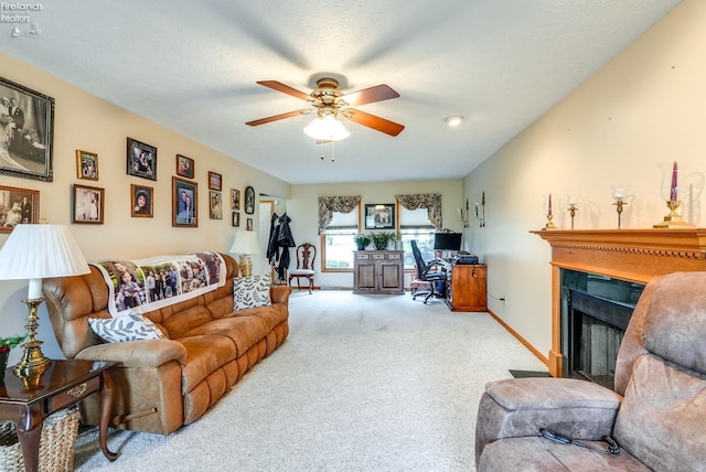 living room featuring light carpet, ceiling fan, and a textured ceiling