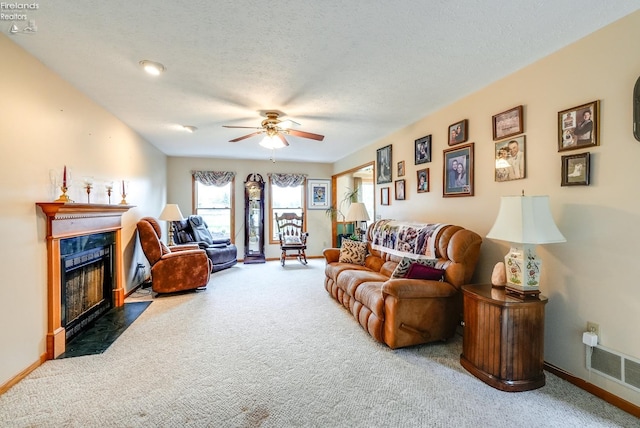 living room with ceiling fan, a textured ceiling, and dark carpet