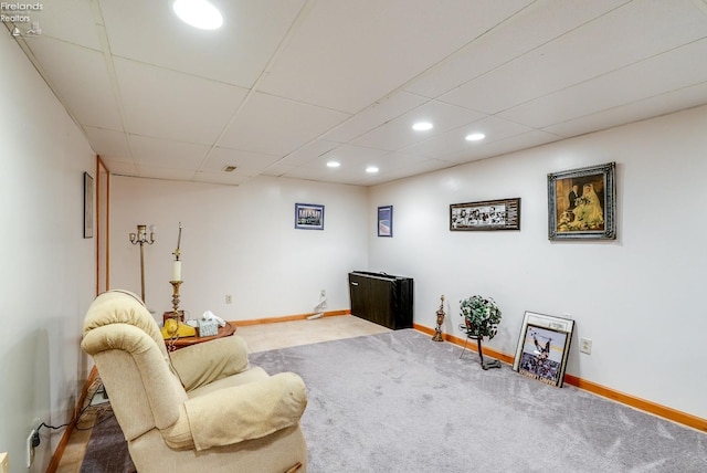 sitting room featuring carpet flooring and a paneled ceiling