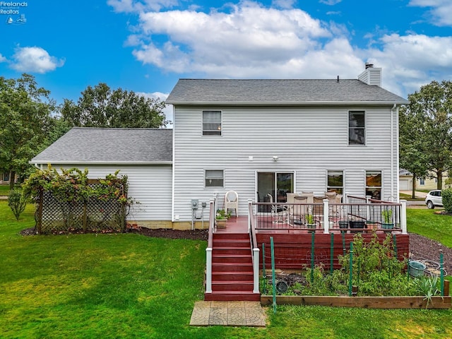 rear view of property featuring a lawn and a wooden deck