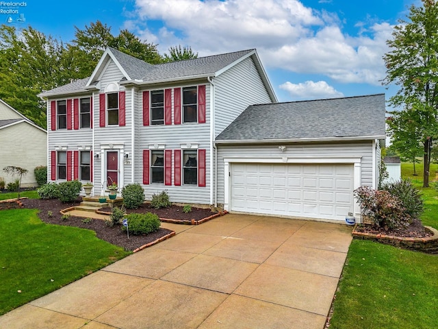 colonial home with a front yard and a garage