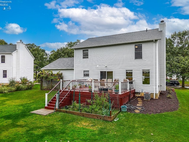 rear view of house with central AC unit, a yard, and a wooden deck