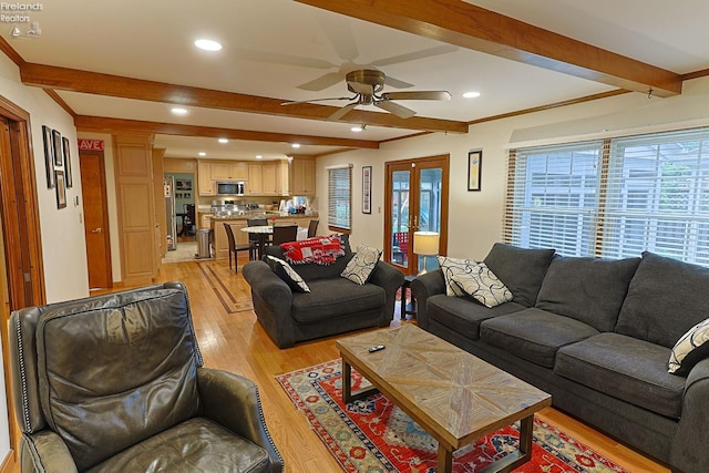 living room with light wood-type flooring, ornamental molding, beam ceiling, and ceiling fan