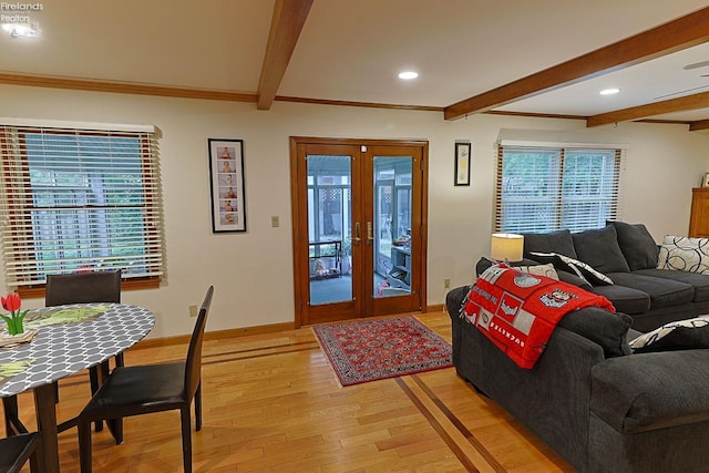 living room featuring beam ceiling, light hardwood / wood-style floors, plenty of natural light, and french doors