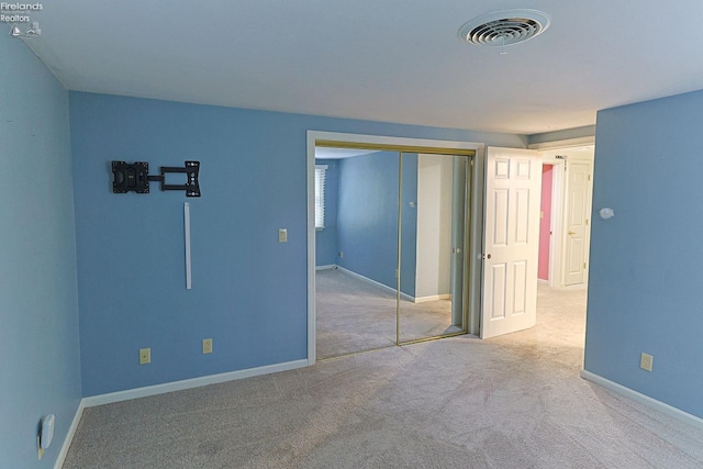 unfurnished bedroom featuring carpet and a closet