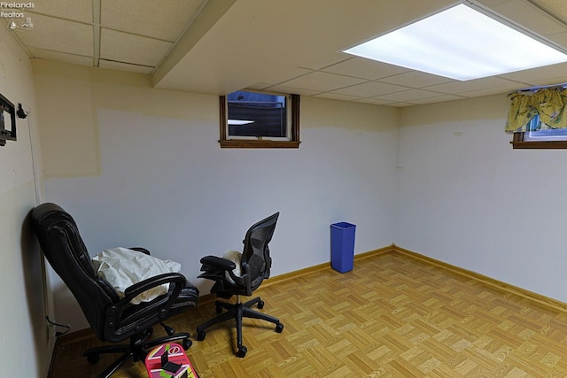 office area featuring light parquet floors and a drop ceiling