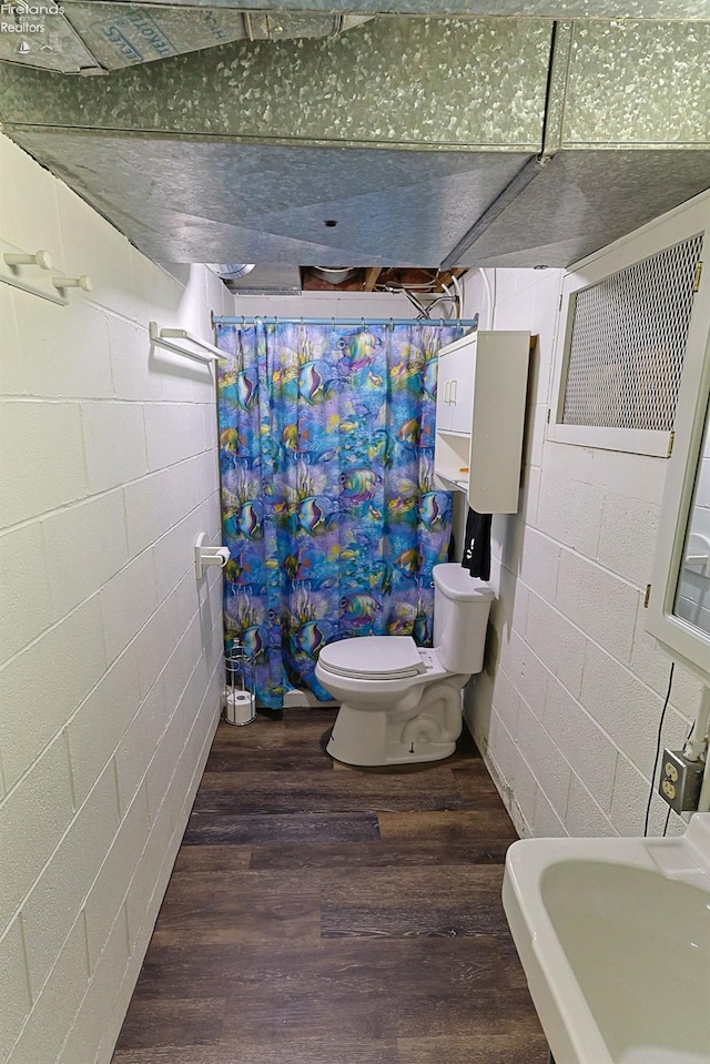 bathroom with hardwood / wood-style floors, toilet, sink, and a shower with curtain