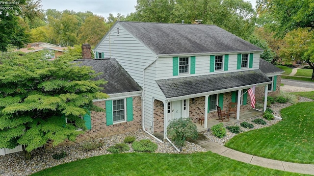 view of front of property featuring covered porch and a front yard