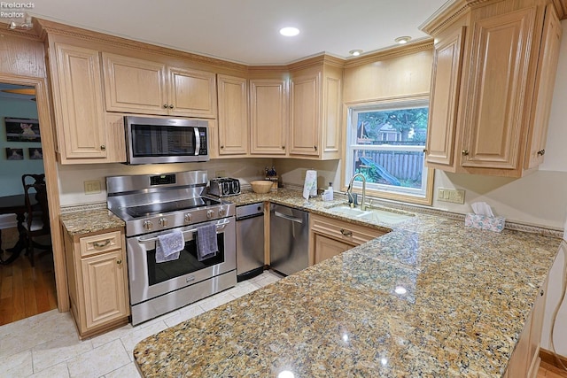 kitchen with light stone counters, sink, light hardwood / wood-style flooring, appliances with stainless steel finishes, and light brown cabinetry