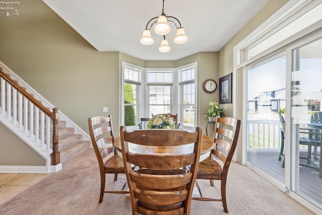 carpeted dining room featuring a chandelier