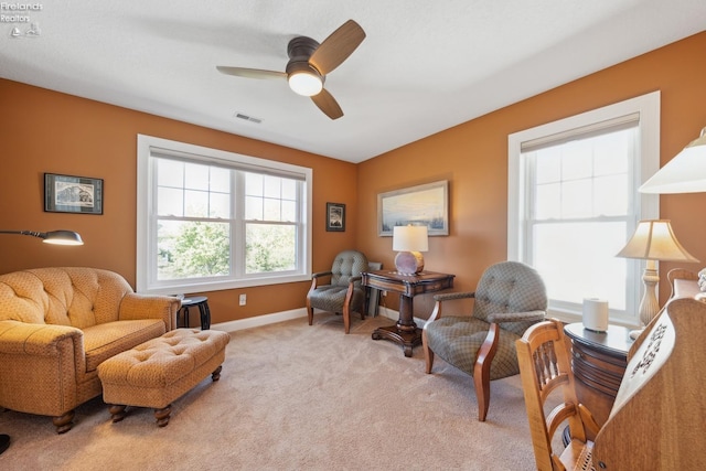 living area featuring ceiling fan and light colored carpet