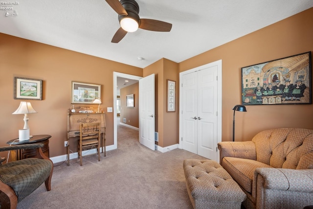 sitting room featuring ceiling fan and light colored carpet