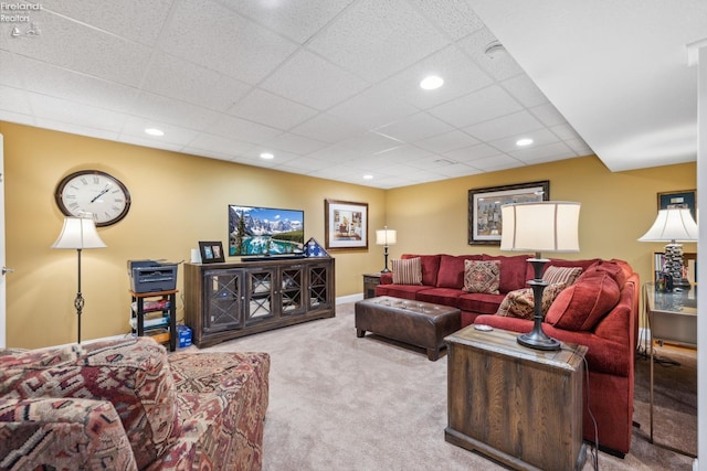 carpeted living room with a drop ceiling