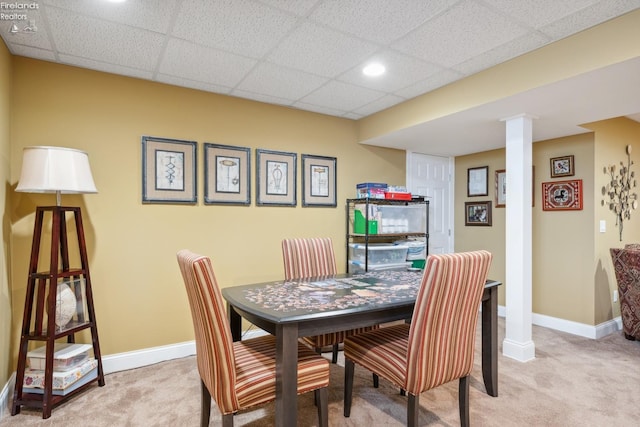 dining space featuring light colored carpet and a paneled ceiling