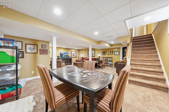 dining space featuring a drop ceiling and light colored carpet