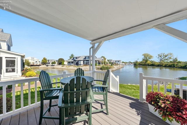 wooden terrace with a lawn and a water view