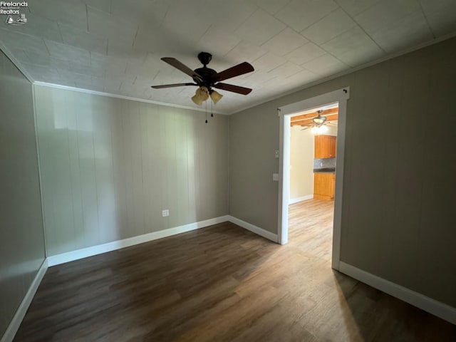 spare room with crown molding, ceiling fan, and wood-type flooring