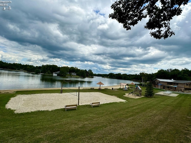 view of community with a water view, playground community, volleyball court, and a lawn