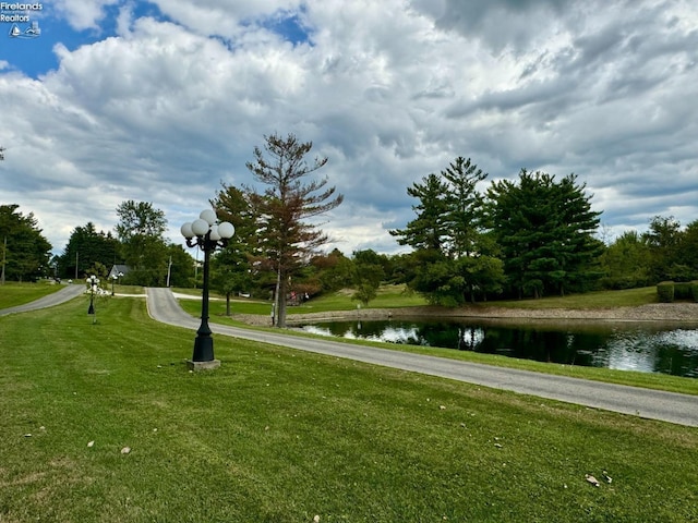 view of community featuring a water view and a yard