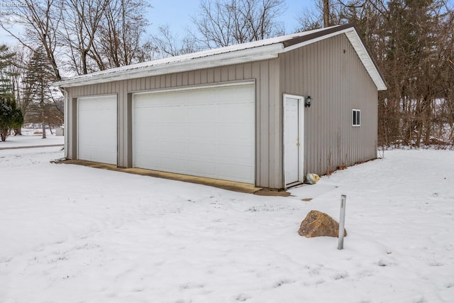 snow covered garage with a garage