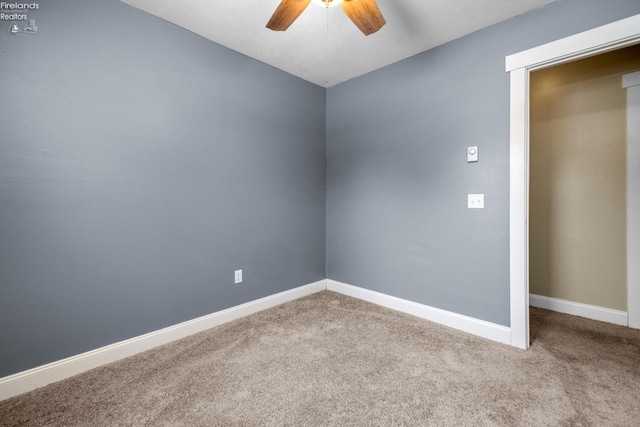 carpeted spare room with ceiling fan