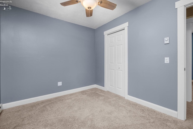 unfurnished bedroom featuring a closet, light colored carpet, and ceiling fan