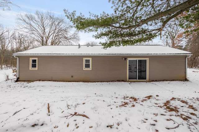 view of snow covered rear of property