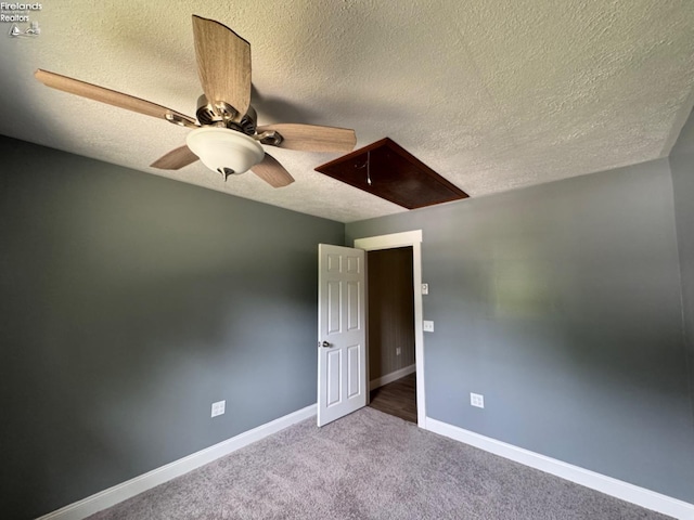 carpeted spare room featuring ceiling fan and a textured ceiling