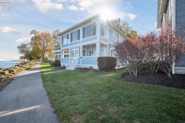 view of front of property featuring a front lawn, a water view, and a porch