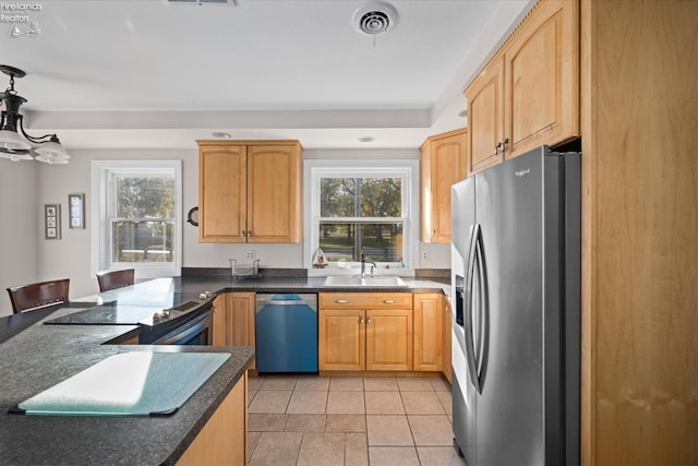 kitchen featuring stainless steel appliances, hanging light fixtures, kitchen peninsula, and a wealth of natural light