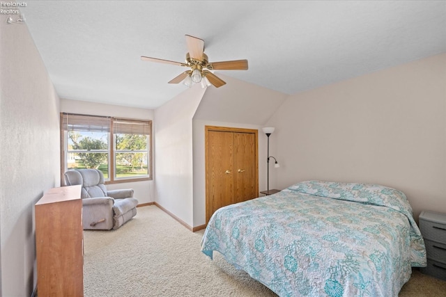 carpeted bedroom with lofted ceiling, a closet, and ceiling fan