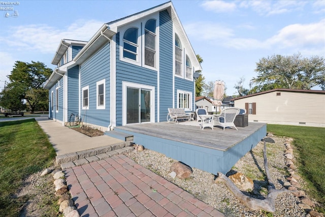 back of property featuring a wooden deck and a lawn