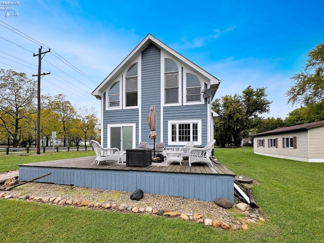 back of property featuring a deck and a lawn