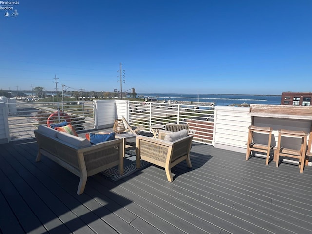 wooden terrace with an outdoor hangout area and a water view