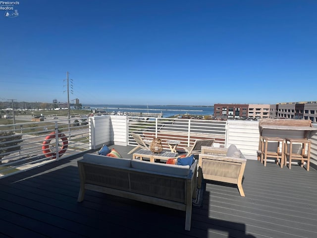 wooden terrace featuring outdoor lounge area and a water view