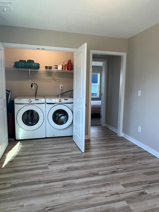 laundry area with washer and dryer and light wood-type flooring