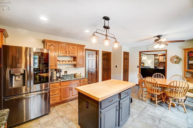 kitchen featuring gray cabinets, stainless steel fridge, decorative light fixtures, butcher block counters, and a center island