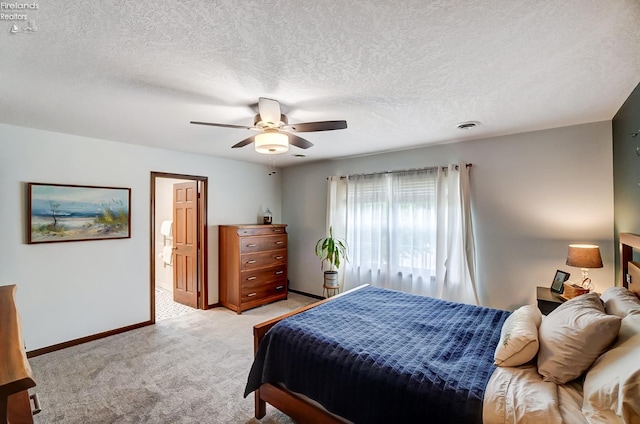 bedroom featuring ceiling fan, light colored carpet, and a textured ceiling