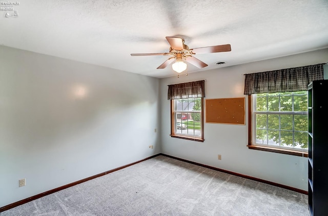 spare room featuring ceiling fan, a textured ceiling, and carpet flooring