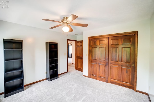 unfurnished bedroom featuring light carpet, a closet, and ceiling fan