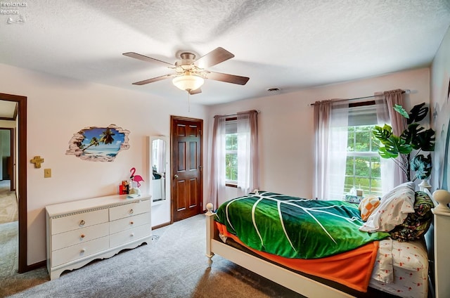 carpeted bedroom with a textured ceiling and ceiling fan