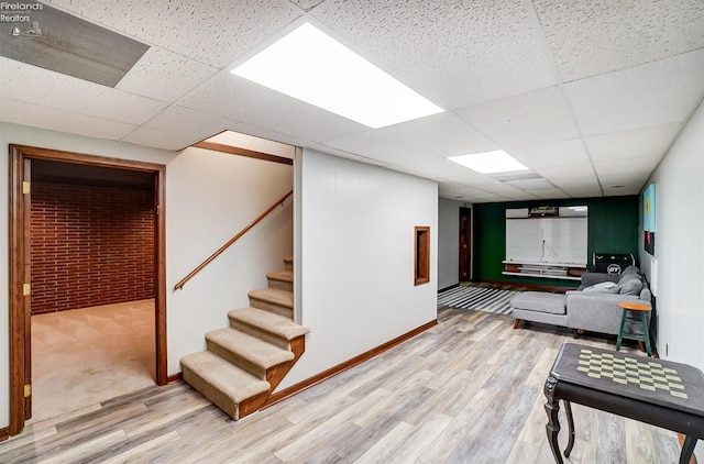 basement with a drop ceiling and hardwood / wood-style floors