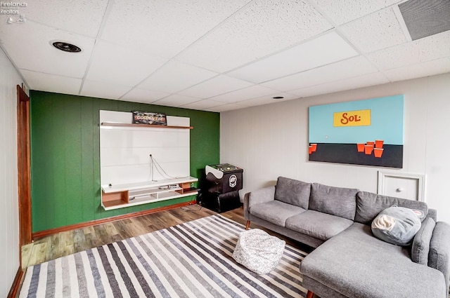 living room with a drop ceiling and hardwood / wood-style floors