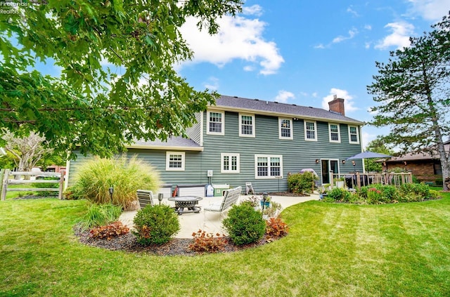 rear view of property with a yard and a patio area