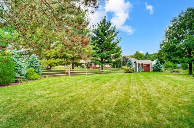 view of yard featuring a rural view and a storage shed