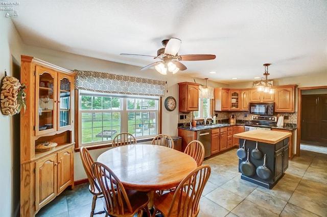 dining space featuring ceiling fan with notable chandelier, sink, and light tile patterned floors